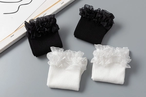 Détail de chaussettes côtelées noires et blanches avec bordure à volants en organza double
