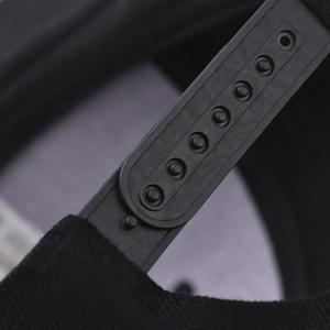 Close-up of the adjustable plastic snapback closure on a black cotton hip-hop baseball cap