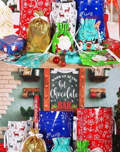 Detailed view of assorted Christmas drawstring gift bags in various sizes and festive colors