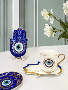 Dettaglio del set da caffè Hamsa in ceramica con motivi Evil Eye e oro