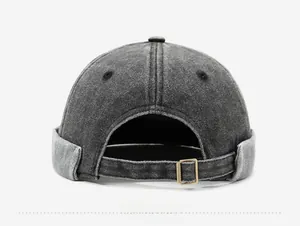 Detail of adjustable metal buckle and washed denim texture on a dark grey docker cap