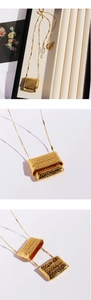 Detailed macro view of gold-plated woven texture rectangular sweater necklace pendant