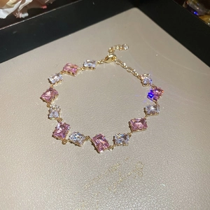 Details des goldenen Tennisarmbands mit rosa und weißen rechteckigen Zirkonia-Steinen