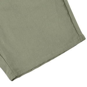 Detailed close-up of double-stitched olive green linen fabric hem showing premium texture