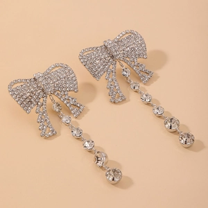 Detail of silver bowknot tassel earrings with pavé rhinestones and dangling crystals