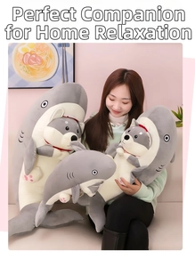 Three sizes of plush shark dog toys held by a model on a sofa for size comparison
