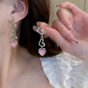 Detailed macro view of heart drop earrings featuring colorful zircons and silver hammered texture