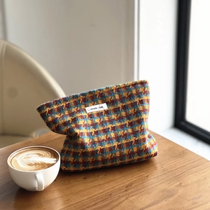 Close-up of colorful checkered tweed texture and 'Simple Wish' woven label on the pouch