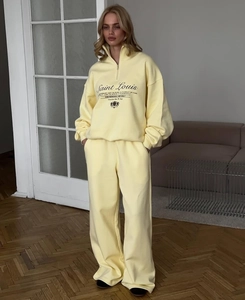 Detail of light yellow tracksuit with embroidered Saint Louis crest and half-zip collar