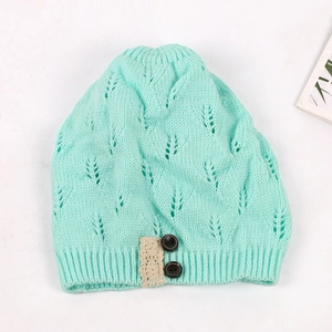 Mint green knitted beanie with hollow leaf pattern and lace button detail