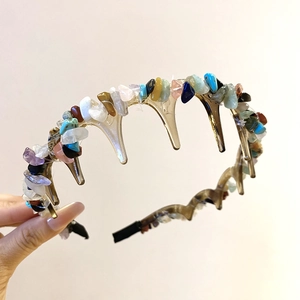 Close-up of vintage acrylic headband with colorful crushed stones and gripping teeth