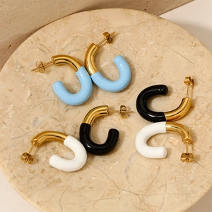 Enamel C-hoop earrings in vibrant colors displayed on a marble jewelry pedestal