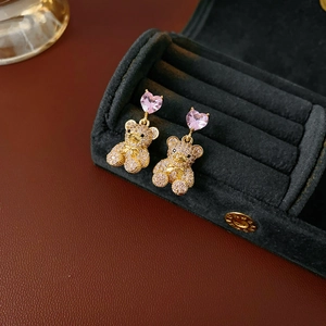 Macro de boucles d'oreilles ours en zircon et cœur rose doré dans un écrin à bijoux