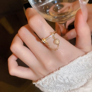 Nahaufnahme eines vergoldeten Quastenrings mit Zirkonia-Anhänger an der Hand
