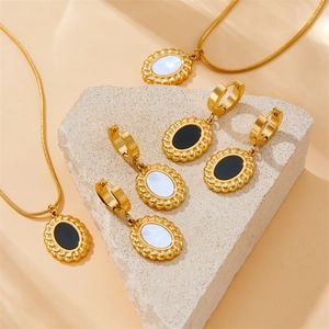 Parure de bijoux vintage en acier doré avec pendentifs ovales noirs et blancs