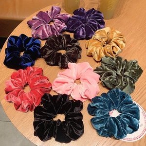 Set van 10 kleurrijke fluwelen scrunchies in diverse kleuren op een rustieke houten tafel