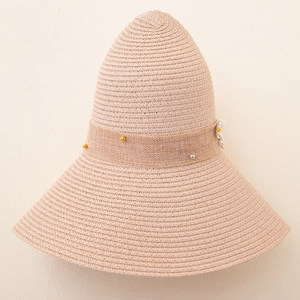 Detail of wide brim straw hat with woven floral band and pearl accents in dusty pink