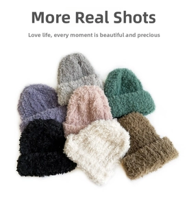 Flat lay of colorful plush knit beanies in gray pink green purple black and white