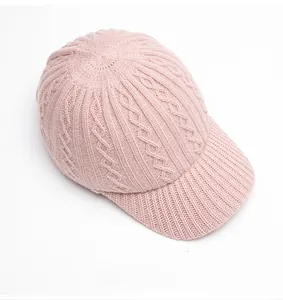Detailed cable knit pattern on pink winter baseball cap showing texture and structure