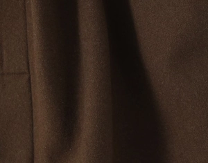 Gros plan sur un tissu épais en laine mélangée marron foncé montrant la texture douce