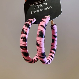 Close-up of leopard print hoop earrings with S925 silver needles on display card