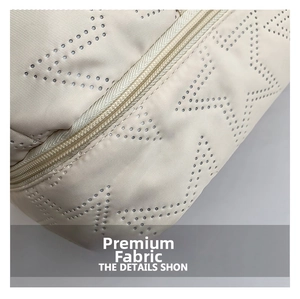 Macro view of beige sport bag featuring laser-cut star patterns and nylon zipper detail