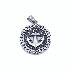 Macro detail of silver stainless steel Viking compass pendant with anchor relief design