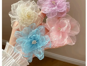 Détail de quatre pinces à cheveux fleurs en organza aux couleurs pastel et perles