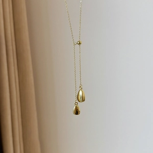 Close-up of 18k gold plated Y-shaped necklace with minimalist asymmetrical teardrop pendants