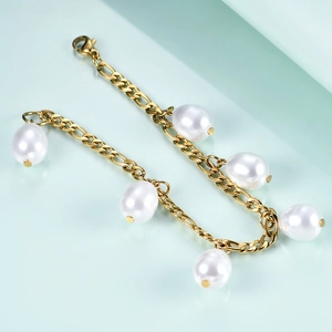Detail of 12mm Figaro chain bracelet with large white pearls on a light blue background