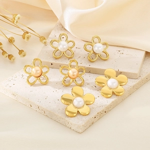 Detailed view of three pairs of gold flower earrings with pearls on silk and stone