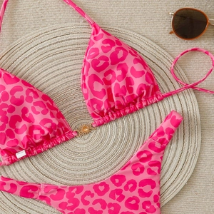 Detail of pink leopard bikini with a golden sun metal buckle on straw mat