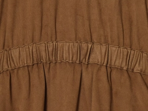 Gros plan détaillé du tissu en daim marron foncé et de la taille élastique plissée