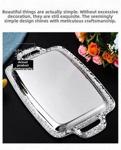 Detailed view of silver rectangular stainless steel tray with embossed floral edge and handles