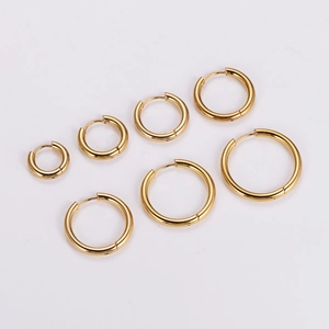 Set of 7 pairs of gold stainless steel hoop earrings in various sizes on white background