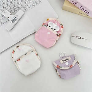 Detailed close-up of colorful floral fabric earphone case with snap button closure