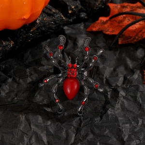 Détail de la bague araignée punk avec cristaux rouges sur fond noir de style Halloween