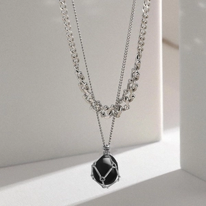 Dettaglio della collana a doppia catena argento con pietra nera in gabbia metallica