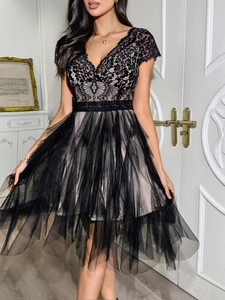 Détail du décolleté en V et de la dentelle noire raffinée sur la robe à manches courtes