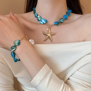 Detail of beach style necklace and bracelet set with blue shells, pearls and starfish