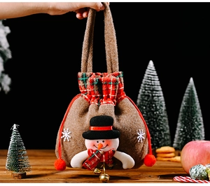 Detailansicht eines braunen Weihnachts-Geschenkbeutels mit 3D-Schneemann und Glocke