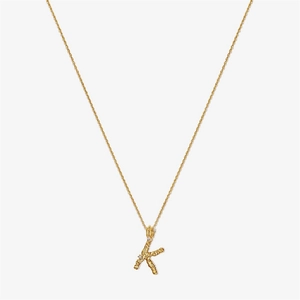 Detail of gold S925 silver letter K pendant with irregular texture and small crystals