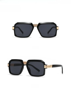 Detail view of black square sunglasses with decorative gold grid metal temple accents