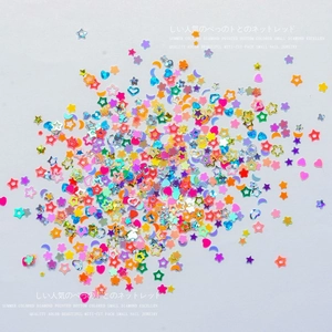 Mix of colorful star and heart glitter sequins for DIY nail art on white background