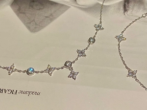 Close-up of silver four-leaf flower bracelet with zircons on a fashion magazine
