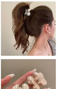 Close-up of pearl cherry hair claw clips for women shown on hair and in hand