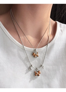 Gros plan d'un collier double épaisseur avec pendentifs cheval en bois et cœur