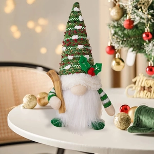 Close-up of a Christmas gnome wearing a red and green knit hat with a wooden sled detail