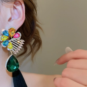 Nahaufnahme der eleganten Blumen-Ohrhänger mit bunten Kristallen und grünem Tropfen