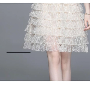 Détail de l'ourlet de la robe en dentelle à plusieurs niveaux montrant des volants